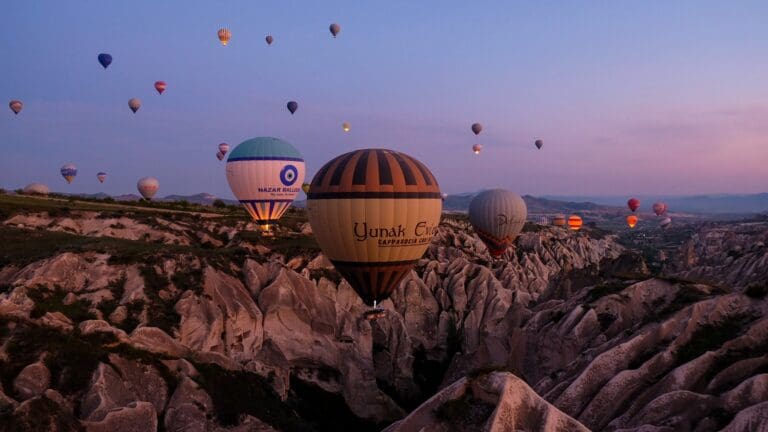 hot air balloons flying over Cappadocia's fairy chimneys at sunrise