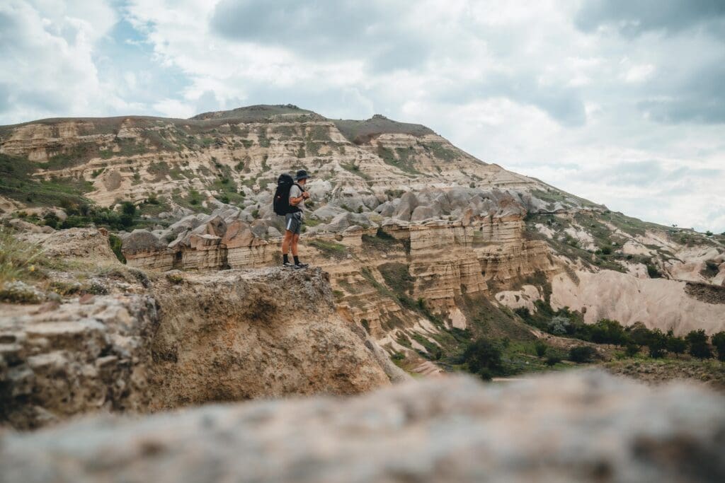 hiker with backpack overlooking the unique landscape of Cappadocia, Turkey