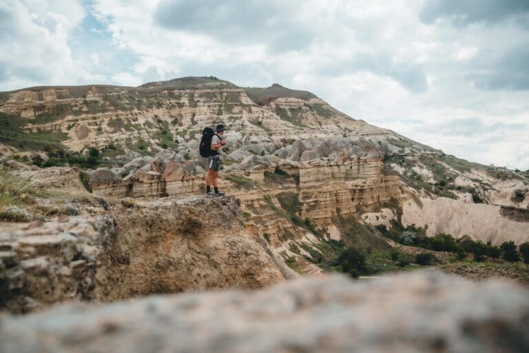 hiker with backpack overlooking the unique landscape of Cappadocia, Turkey